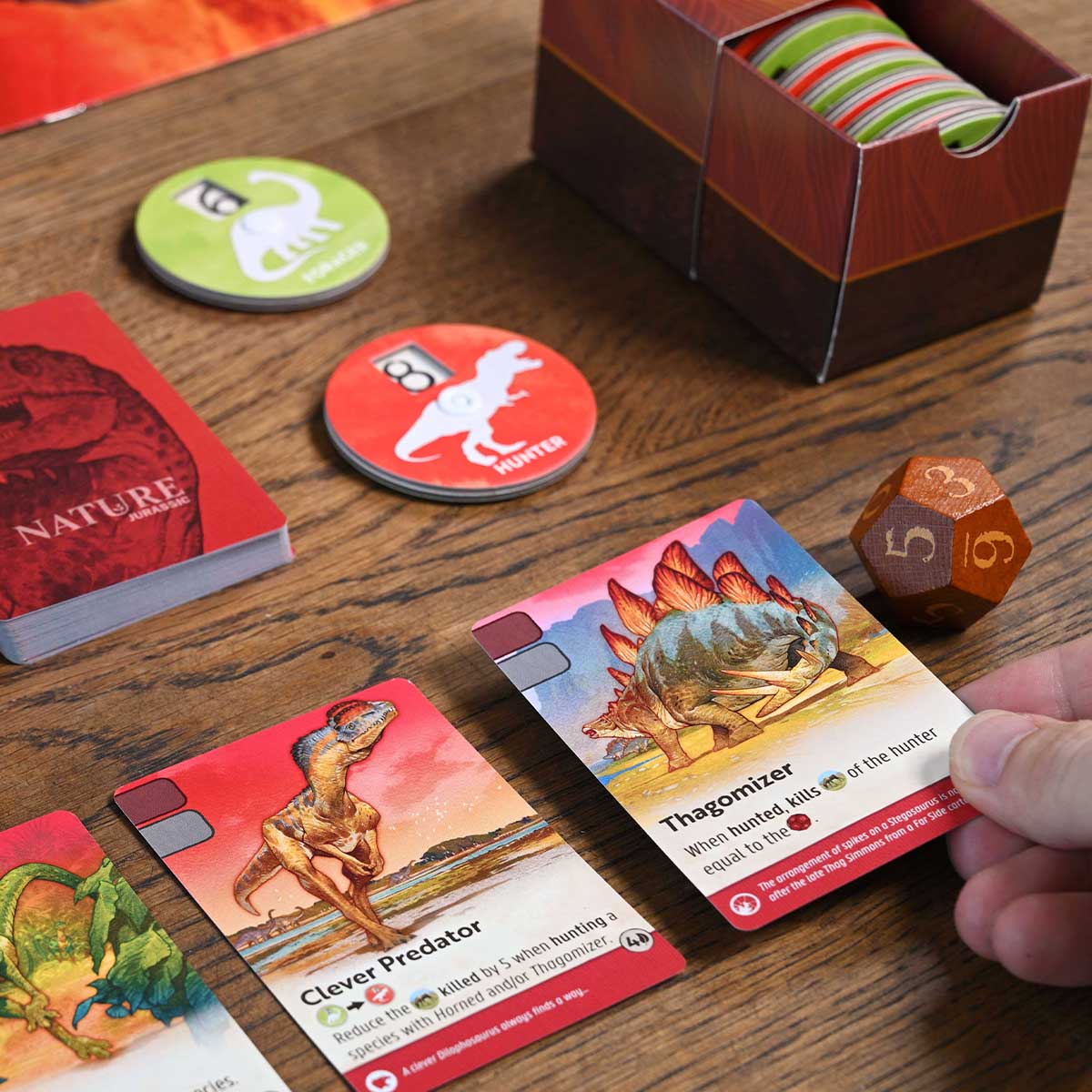Board game cards with dinosaur illustrations on a wooden table