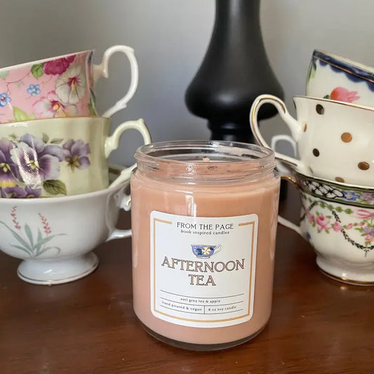 Jar of 'Afternoon Tea' candle with vintage teacups in the background