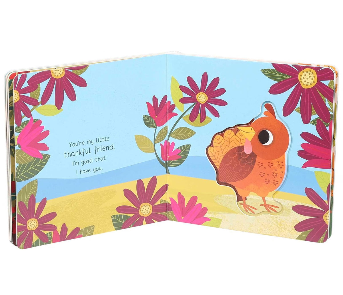 An open children's board book featuring a colorful illustration of a small orange bird standing among pink flowers on a yellow ground under a light blue sky. The left page has the text, 'You're my little thankful friend, I'm glad that I have you.