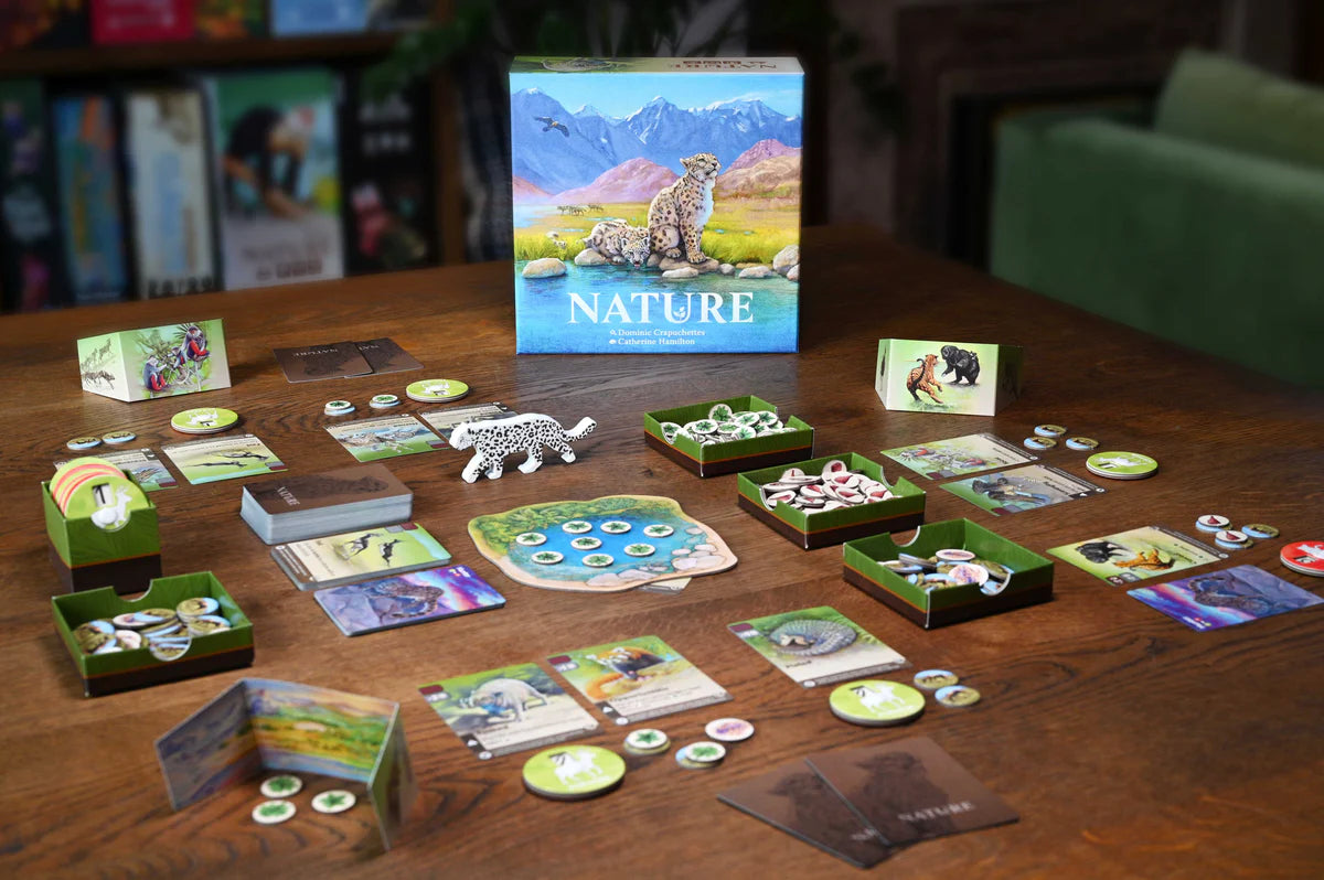 Board game set up on a table with nature-themed cards and pieces.