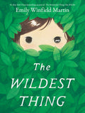 Book cover of 'The Wildest Thing' by Emily Winfield Martin, featuring a child peeking through leaves.
